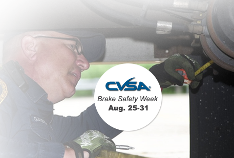 Image shows officer inspecting a vehicle's brakes.